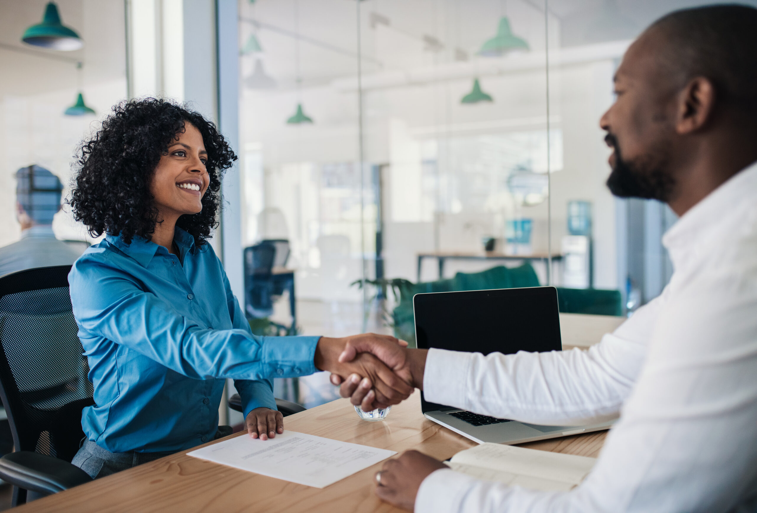 Smiling,African,American,Manager,Sitting,At,His,Desk,In,An